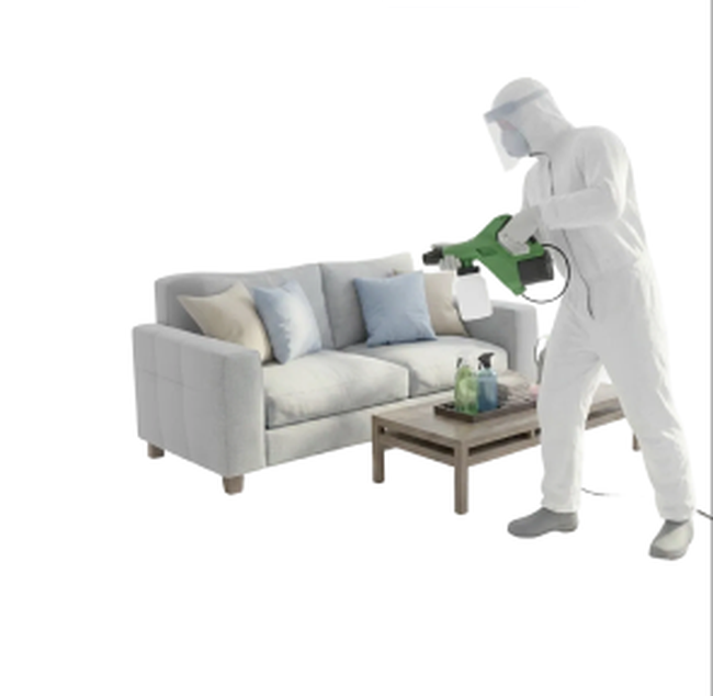 Technician in a protective suit disinfecting a sofa
