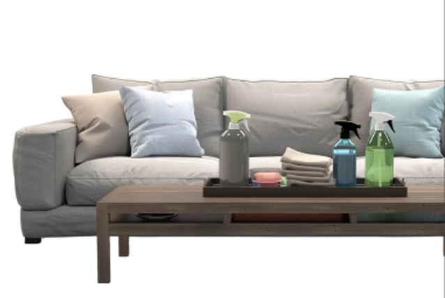 Grey sofa with cushions and a coffee table holding eco-friendly cleaning supplies