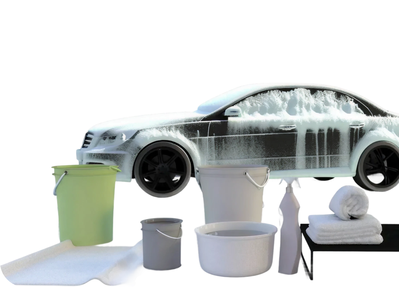 A car covered in foam next to wash buckets and towels