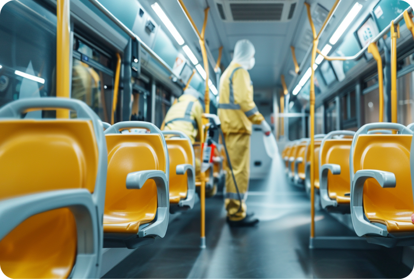 A cleaner in protective gear sanitising a tram interior